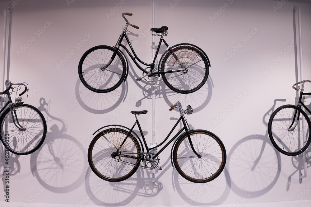 Naklejka premium Old bicycles hang on a white wall as decorations