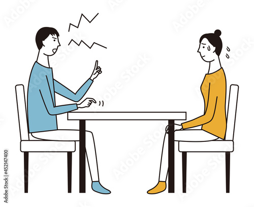 テーブルをはさんで女性に向かって怒る男性