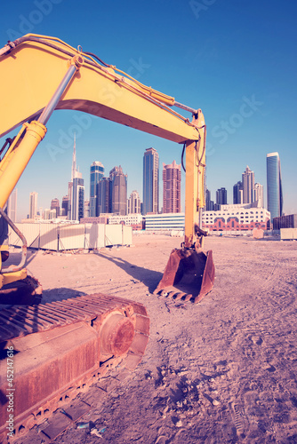 Obraz na płótnie Bulldozer on the sand against the backdrop of skyscrapers in Dubai as a symbol of UAE development w salonie