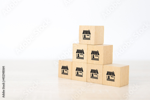 Franchise, Close-up cube wooden toy block stack in pyramid with franchises store icon for small business standard and best quality for business growth and branch expansion and bank loan.