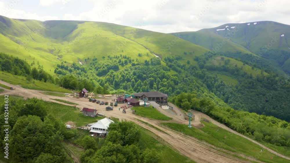Rosa Khutor plateau, buildings, slopes and chair lifts. Aerial view of the ski resort slopes at summer with mountain bike roads. Rosa Khutor plateau, buildings, slopes and chair lifts. Aerial view of the ski resort slopes at summer with mountain bike roads.