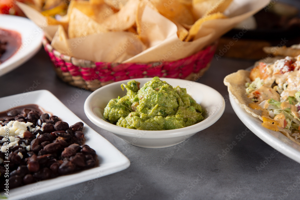 A view of a side of guacamole, among other Mexican and Tex-Mex entrees. A view of a side of guacamole, among other Mexican and Tex-Mex entrees.