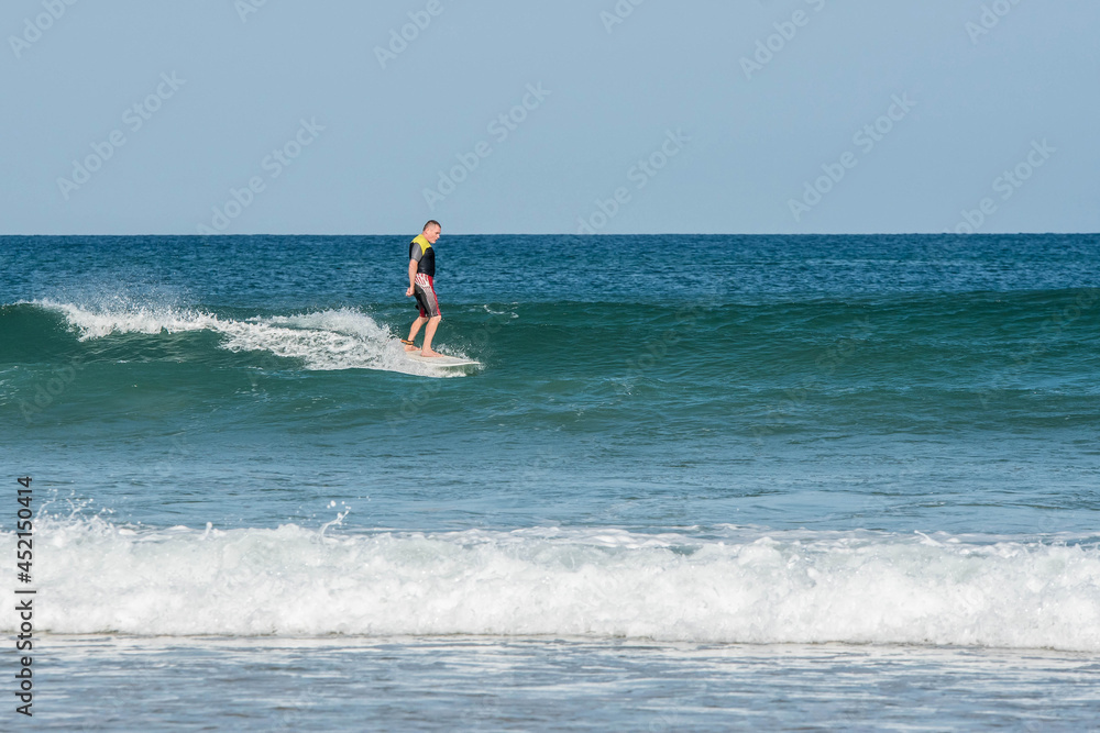 middle aged surfer in action in the waves middle aged surfer in action in the waves