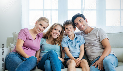 Portrait of lovely little caucasian boy teenage girl parents sit on sofa living room. Happy fun caucasian family with father mother daughter son, family's day, healthcare stay home at apartment