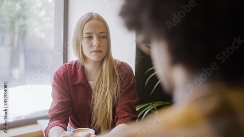 Fotografia Young offended woman having fight with boyfriend in cafe, not talking to each ot