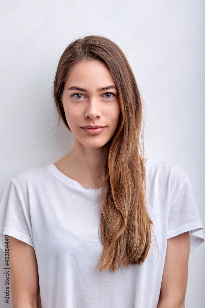 Calm Diligent Female With Natural Long Hair In Casual T-shirt Posing Smiling Isolated On White Studio Background, Portrait Of Lady With Natural Beauty Looking At Camera. Copy Space Calm Diligent Female With Natural Long Hair In Casual T-shirt Posing Smiling Isolated On White Studio Background, Portrait Of Lady With Natural Beauty Looking At Camera. Copy Space