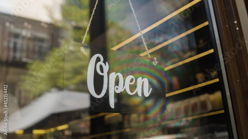 Open sign hanging on door, beginning of work day, small business development photo