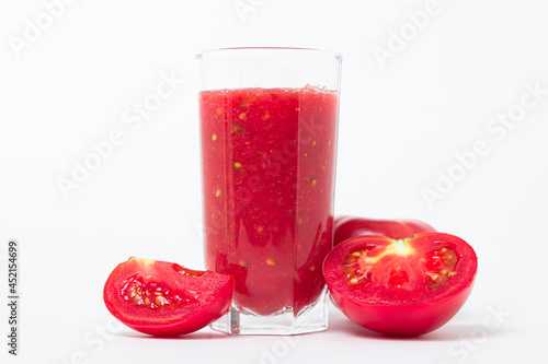 A glass of tomato juice on a white background. Natural freshly squeezed tomato juice.