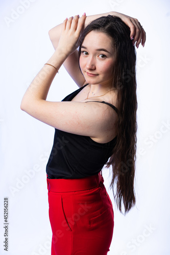 half-length portrait of a girl. acne on the body, skin problems. model in a black t-shirt. long curly hair. white, isolated background