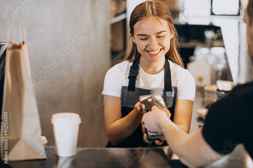Obraz na plátne Customer paying with card in a coffee house