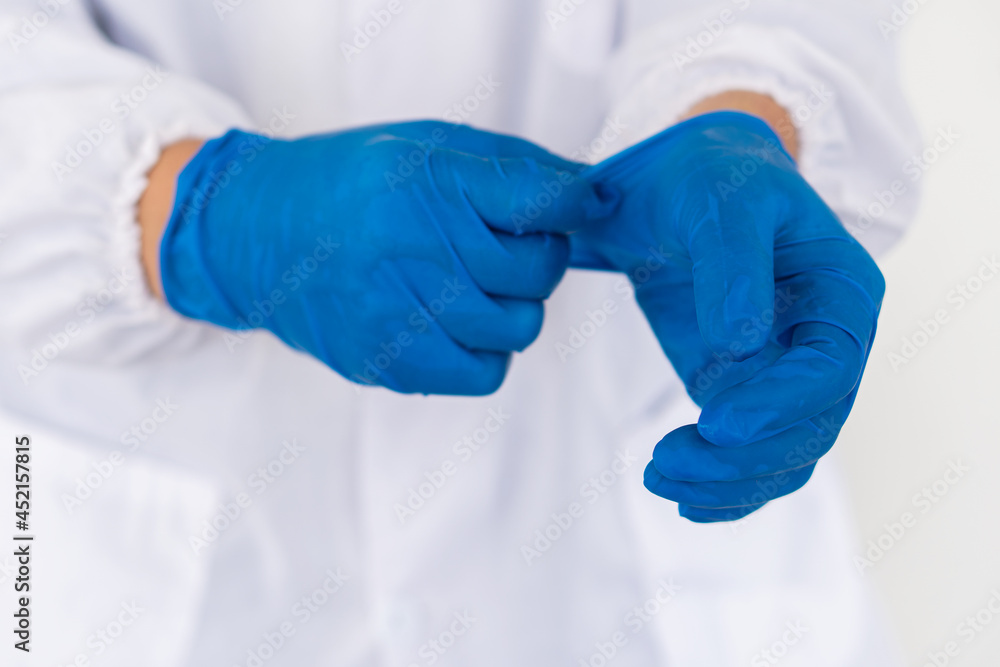 Doctors are removing blue gloves after finishing work.
Doctors are removing blue gloves after finishing work.
