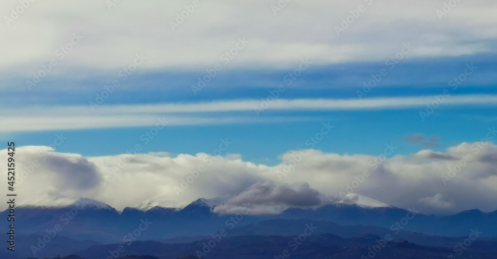 Fototapeta premium Nuvole ovattate sopra le cime innevate dei monti Appennini