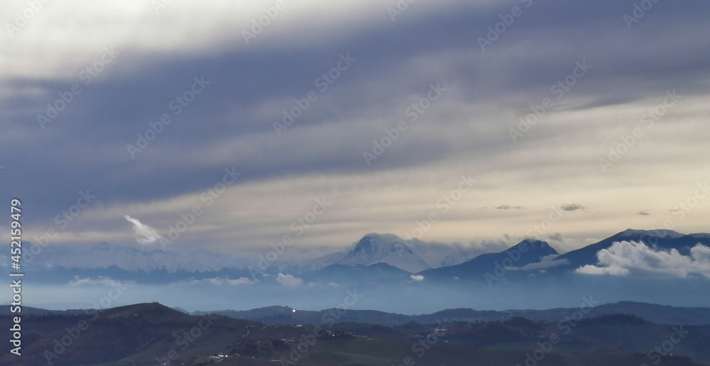 Nuvole ovattate sopra le cime innevate dei monti Appennini Nuvole ovattate sopra le cime innevate dei monti Appennini
