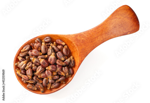 Dried grape seeds in the wooden spoon, isolated on white background, top view