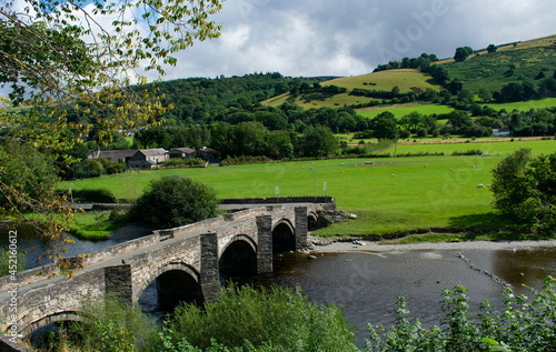 Old stone bridge over the river Dee, near Llangollen, north Wales.  Landscape aspect view. Rural scene with Green fields and wooded hills.
