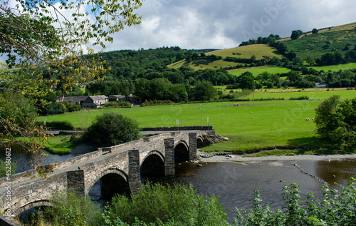 Old stone bridge over the river Dee, near Llangollen, north Wales.  Landscape aspect view. Rural scene with Green fields and wooded hills. photo
