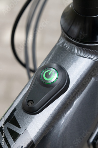 Green glowing power button on electric bicycle, scooter or other vehicle.