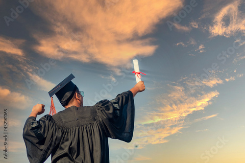 The graduates raised their hands to celebrate graduation with a certificate in hand and her feelings of pride and happiness.