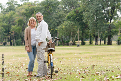 Happy couple seniors standing relax after riding bicycle in the park.Senoir retirement concept