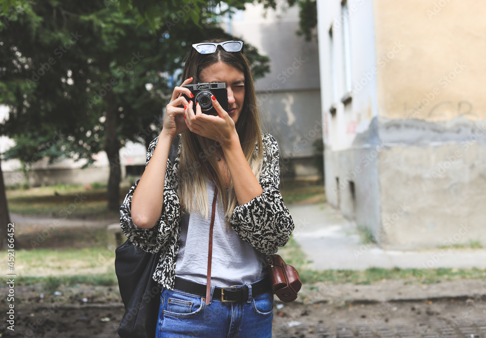 Girl taking picture with a vintage camera.