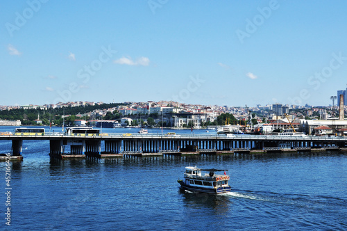 Panoramic view of the bridge over the Golden Horn Bay. Bridge, pleasure ship and residential buildings of the city. 09 July 2021, Istanbul, Turkey.