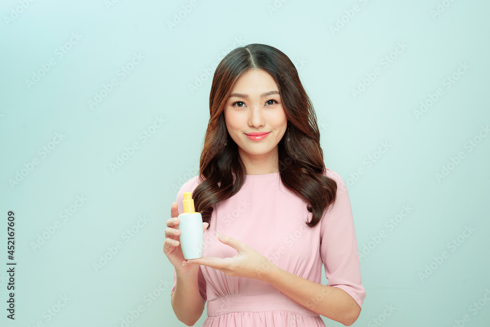 smiling young woman showing skincare products smiling young woman showing skincare products