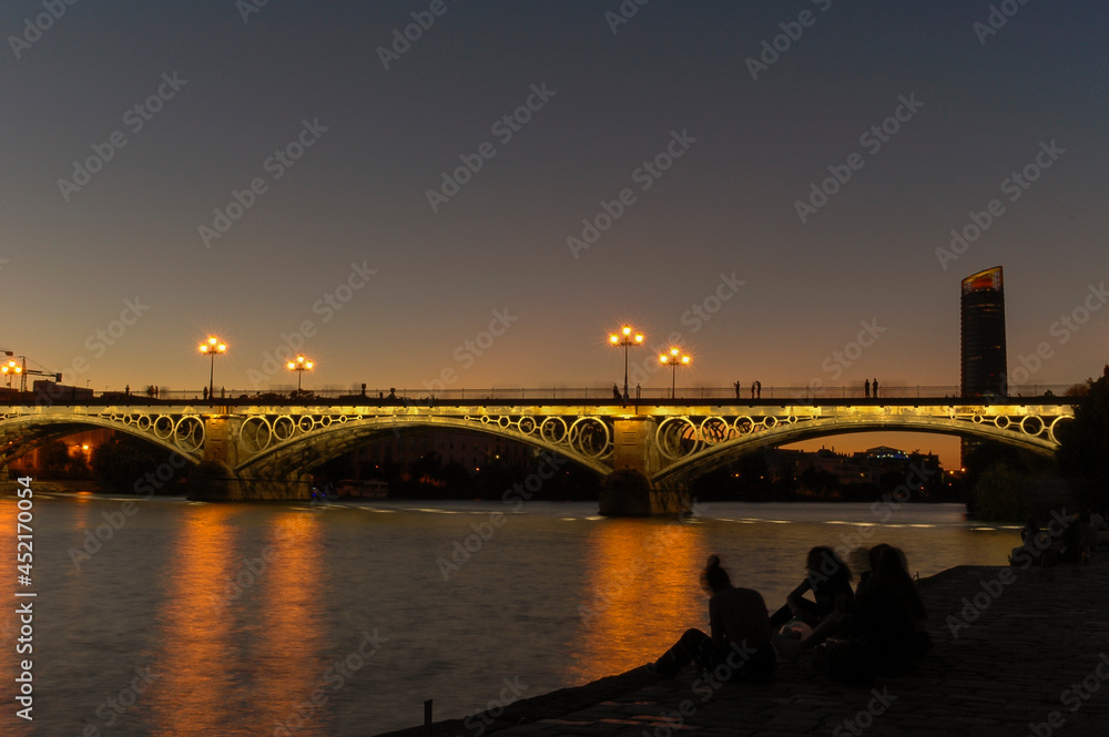 Metal bridge Puente de Triana at night | Seville, Spain