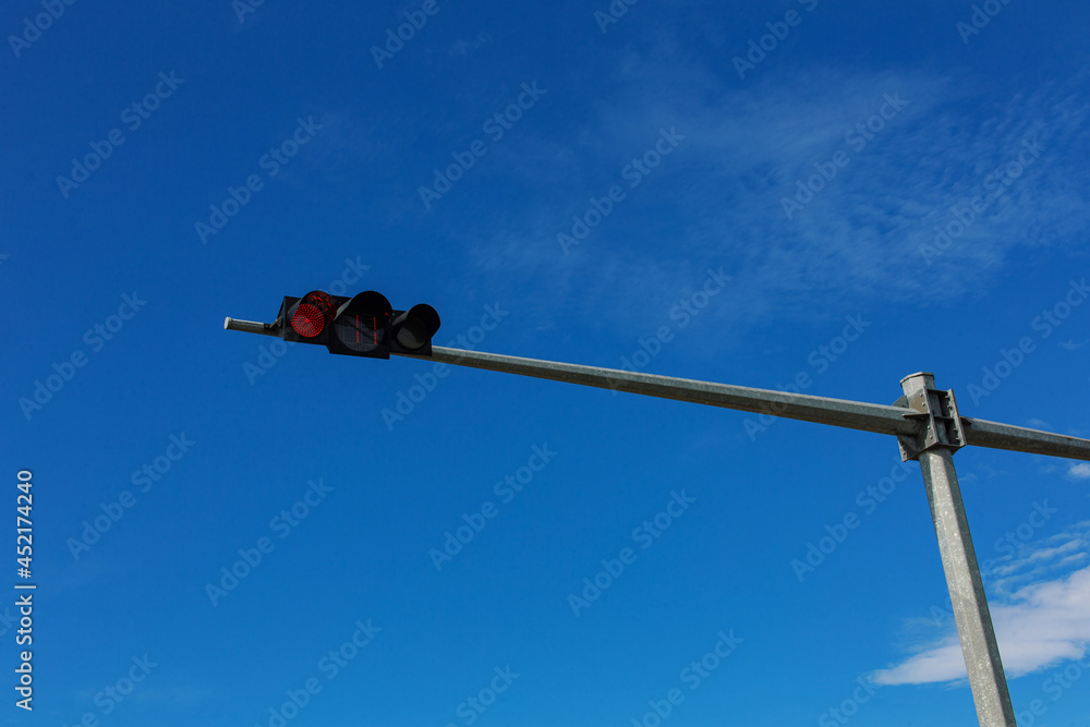 Traffic light pole at red light and blue sky