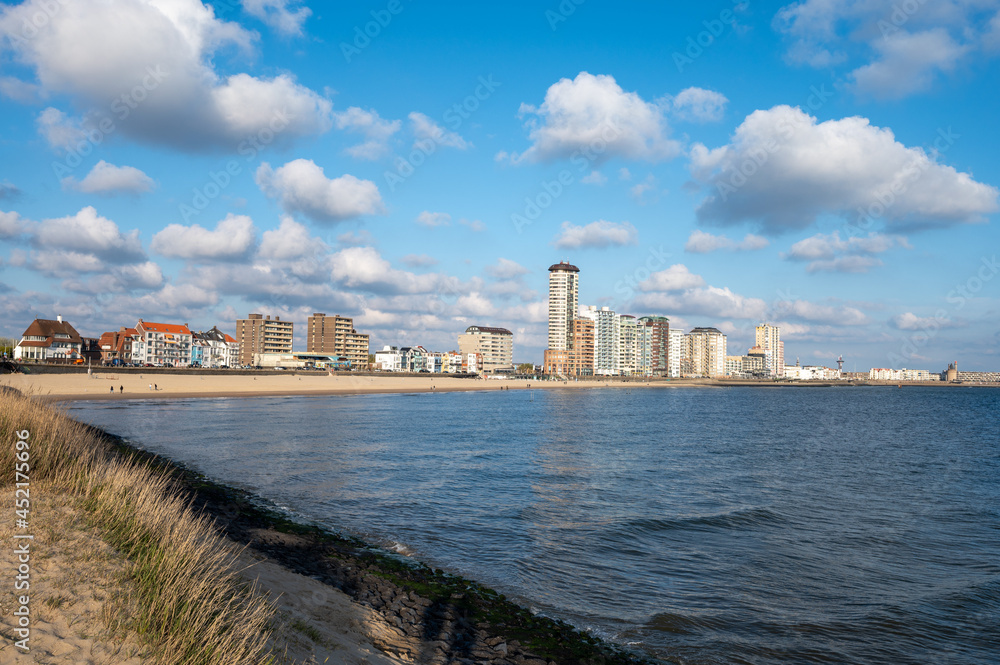 Waterfront, dunes and view on Vlissingen city with sandy beach on sunset