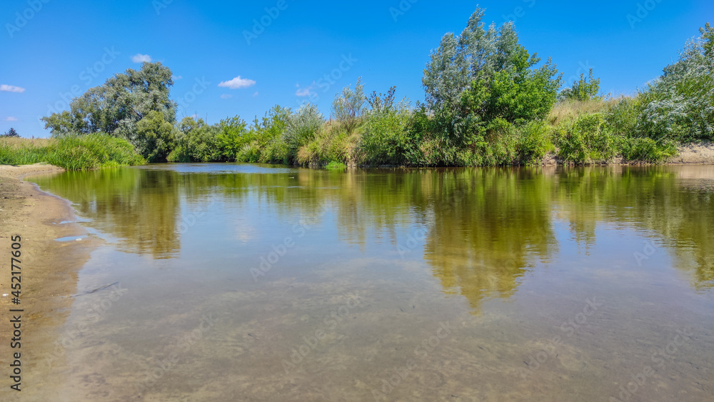 Landscape with a lake and clouds in the sky in the summer season Landscape with a lake and clouds in the sky in the summer season