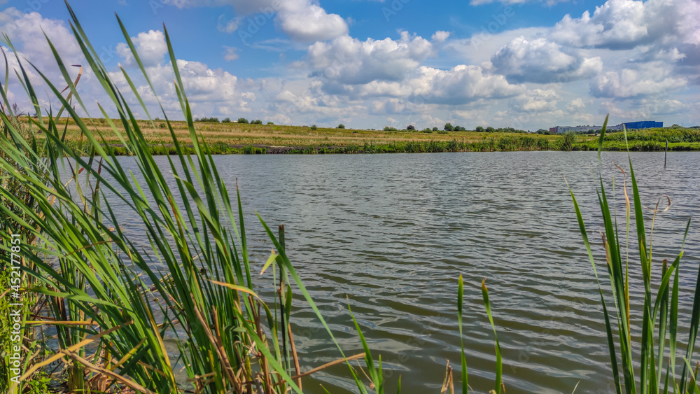 Fototapeta premium Landscape with a lake and clouds in the sky in the summer season