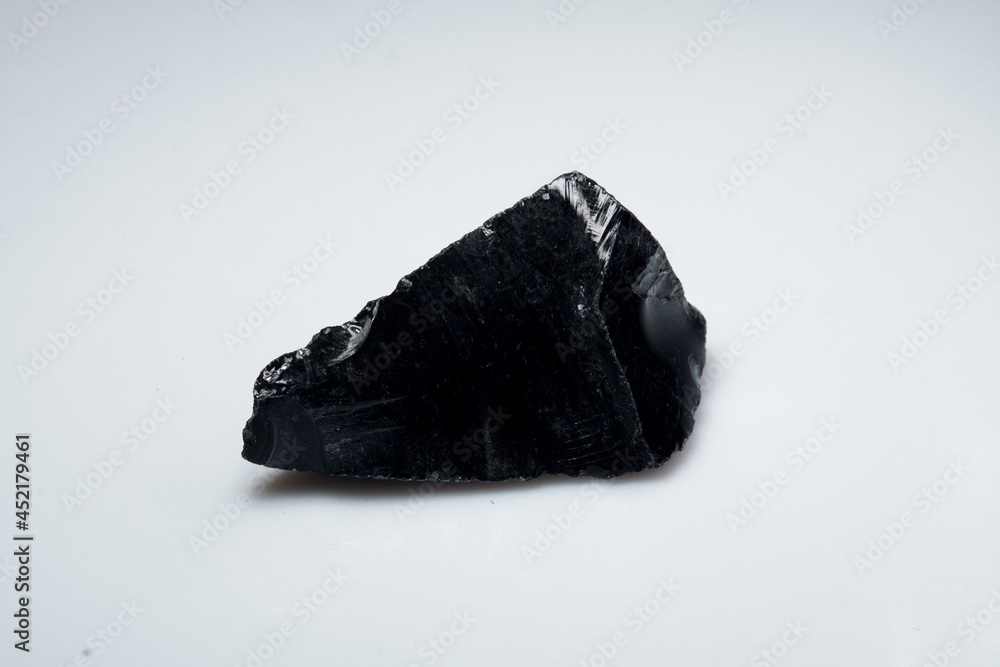 Natural black obsidian stone on white background Natural black obsidian stone on white background
