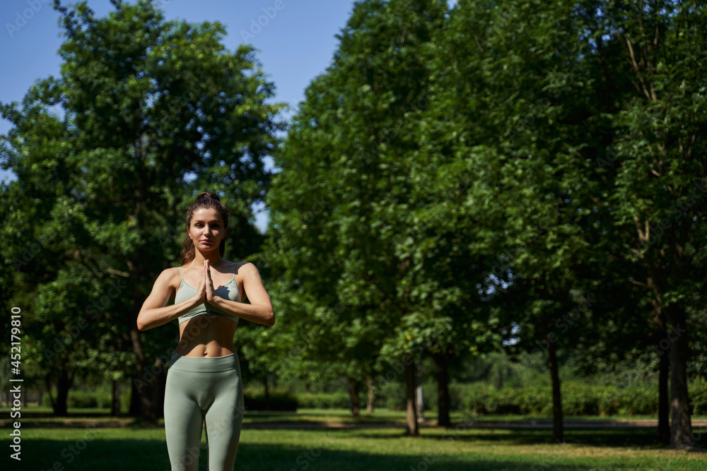woman meditates in the park. woman in the park doing yoga. pilates, gymnastics in the summer. sport exercises. young sports woman.