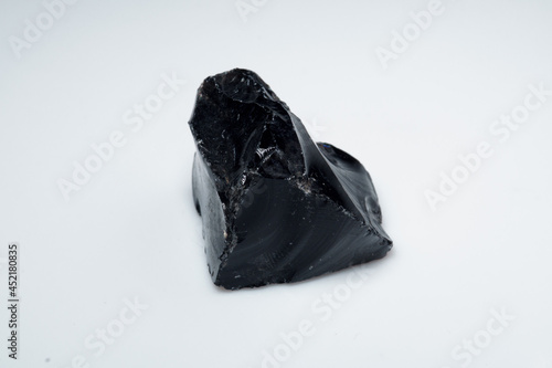 Natural black obsidian stone on white background