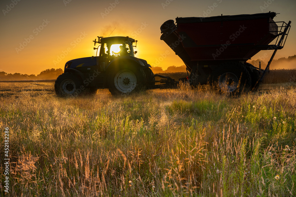 Fototapeta premium Coucher du soleil sur un tracteur en plein moisson dans le département de l'Oise