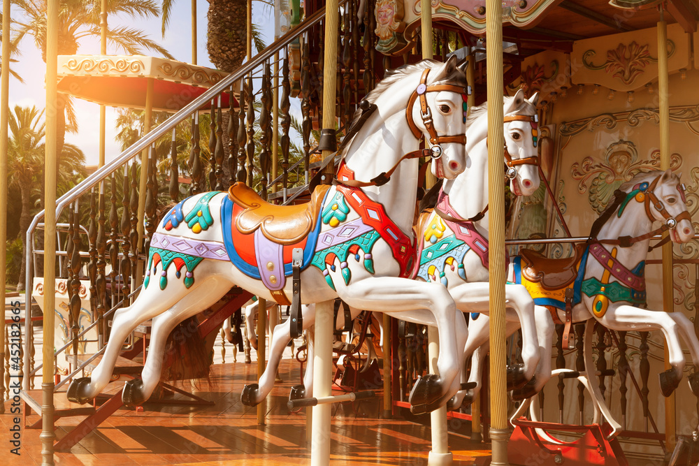 Close-up of merry go round carousel horses in sunset