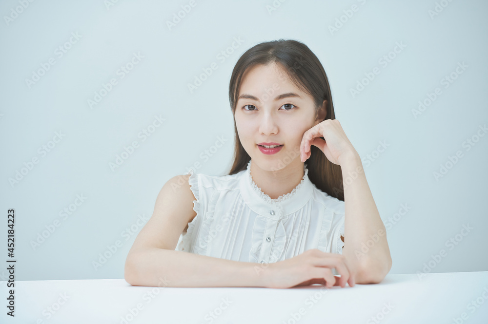 肘をつくポーズをする若い女性 肘をつくポーズをする若い女性
