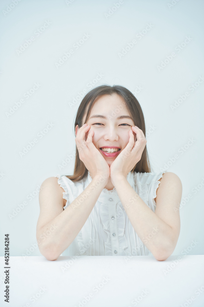 肘をつくポーズをする若い女性