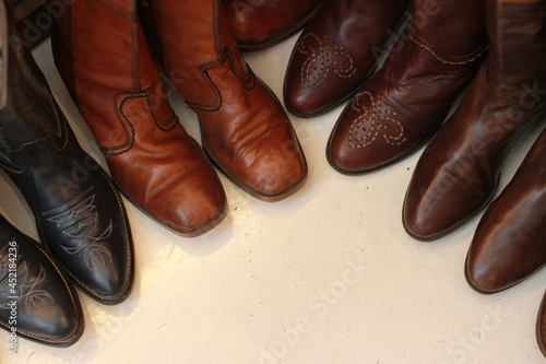 Cowboy boots in various styles on the ground.