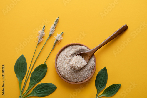 Slika na platnu Psyllium, isfagula plant product is the husk of plantain seeds in a plate on a yellow background