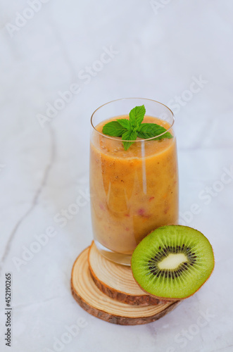 Top view of fresh healthy smoothie in a glass made of peach, banana and berries. Creative concept of healthy detox drink, diet or vegetarian food concept. Copy space.