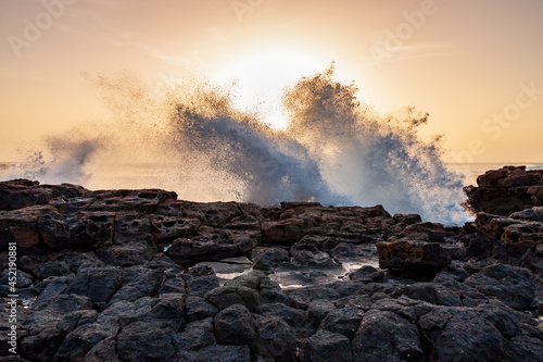 Crashing waves with sunset in background