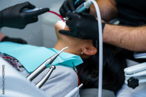 Dentist curing a female patient in the stomatology. Teeth treatment concept. Cropped photo