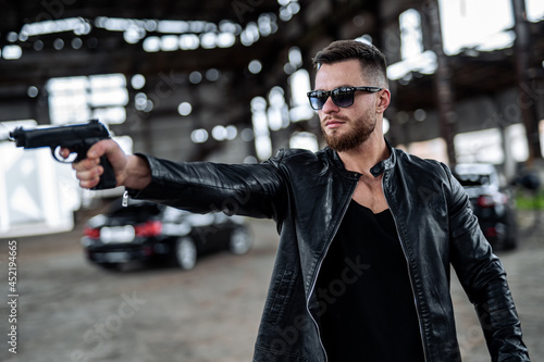 Canvas Print Brutal male points a gun on a point