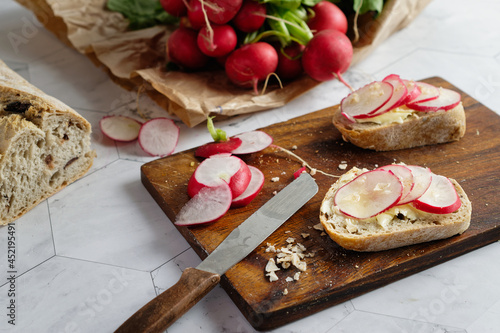 Sliced radishes on slices of whole wheat baguette bread with butter. 