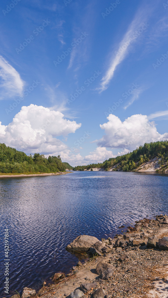 River with trees, rocks and cloudy sky in Kareliya  vertical photo
