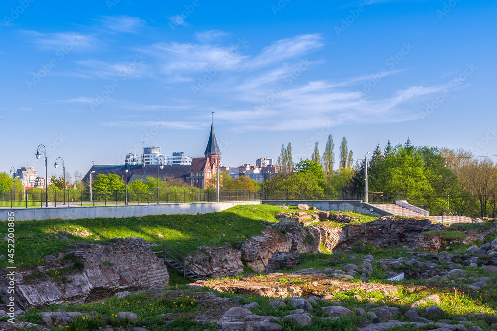 Ruins of the Koenigsberg castle in the historic city center on a sunny spring day. In the background there is the Cathedral on the island of Kant. Russia, Kaliningrad