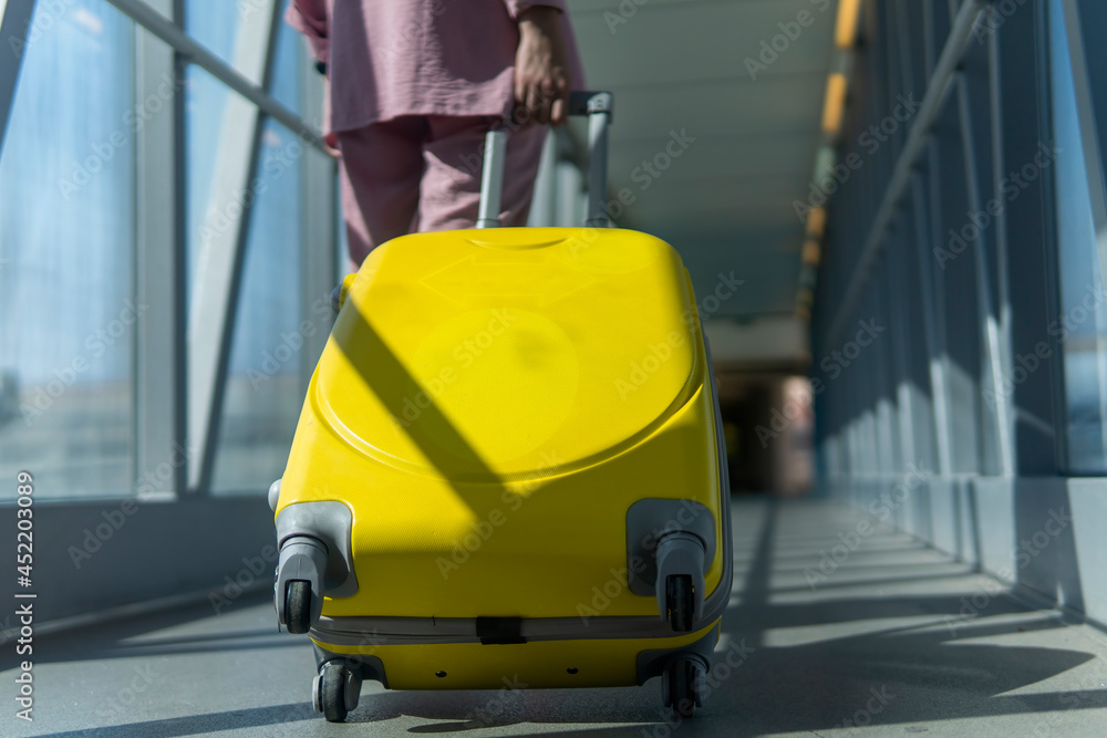girl with a yellow suitcase walk through the terminal to the airport girl with a yellow suitcase walk through the terminal to the airport