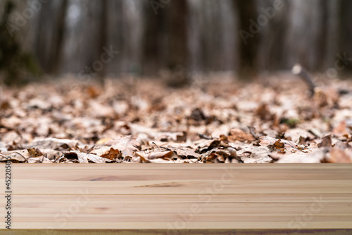 Wood table and blur green tree nature backdrop. Empty wooden table top  surface over blurred garden outdoor