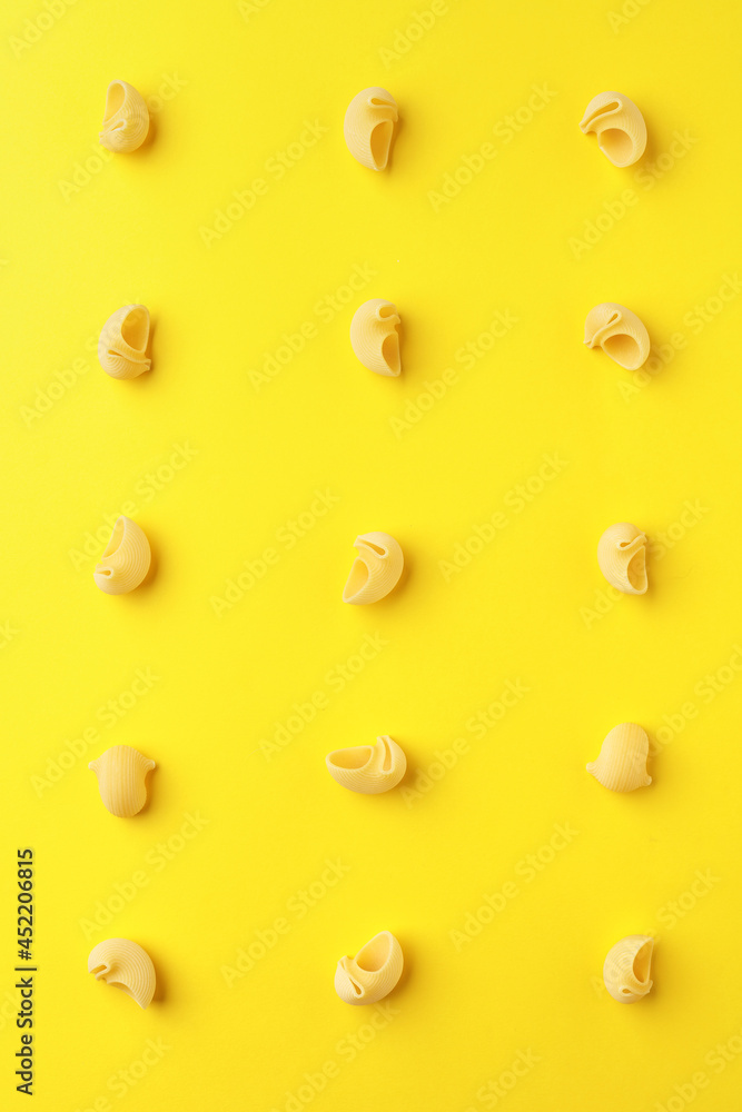 Pasta lumaconi on a yellow background.